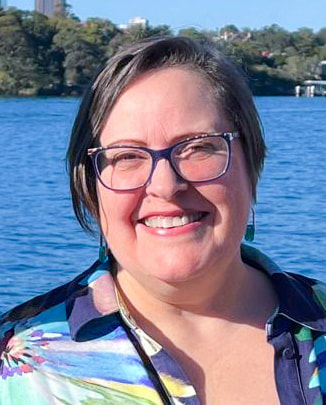 Portrait photo of Melinda wearing a colourful dress.